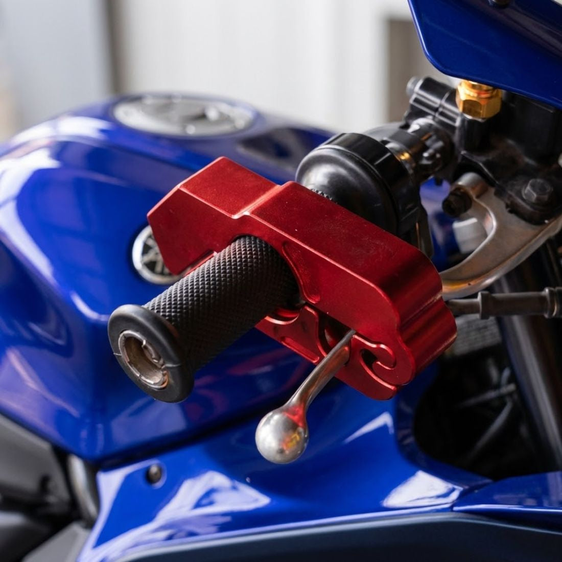Red brake lever lock installed on blue motorcycle handlebars